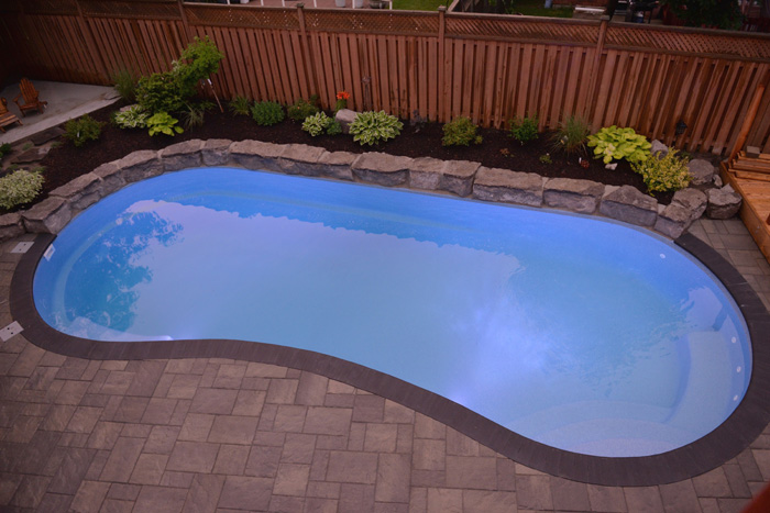 Fiberglass swimming pool in a backyard