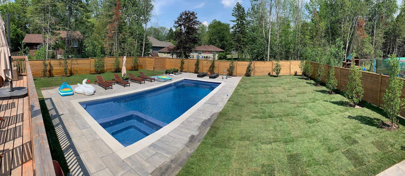 Finished fiberglass pool installation with a beautiful yard