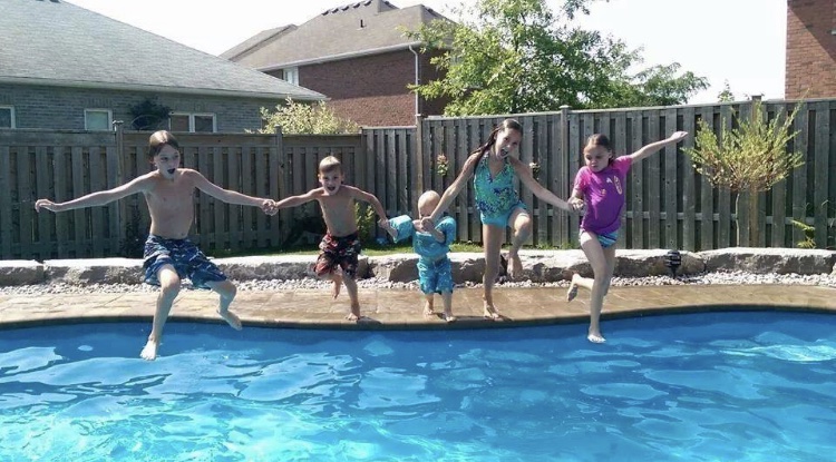 Kids jumping into a swimming pool