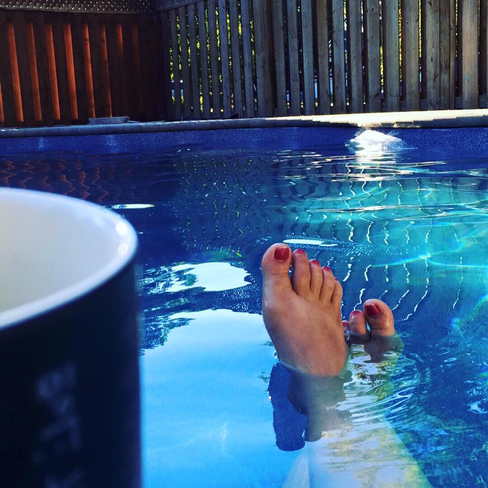 Person relaxing in their beautiful fiberglass swimming pool