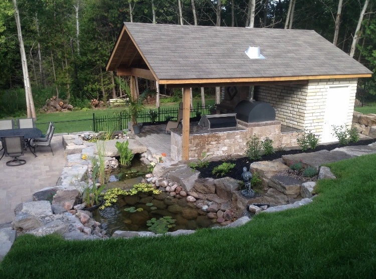 Pool house next to a garden and pond